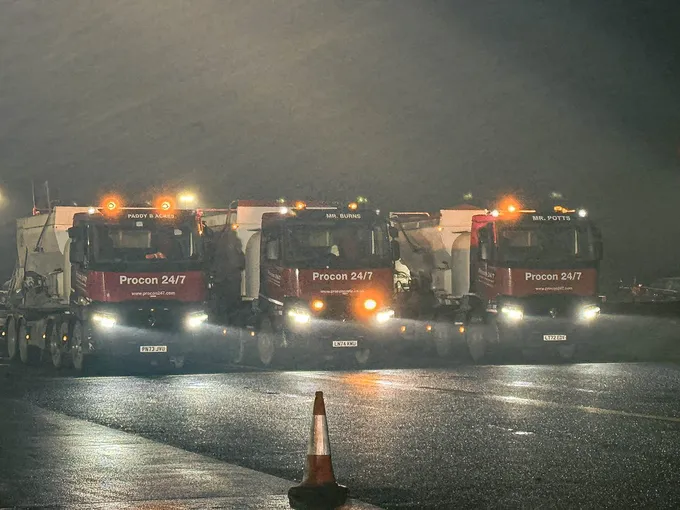 Procon fleet of volumetric mixers parked at an airport at night