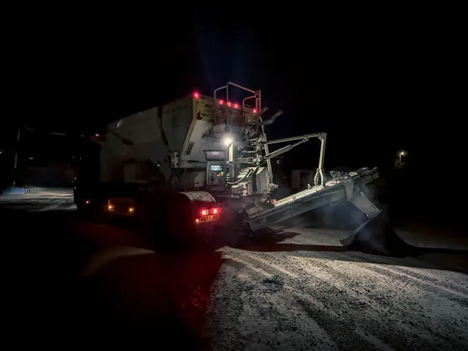 Procon volumetric mixer discharging concrete down the chute at night